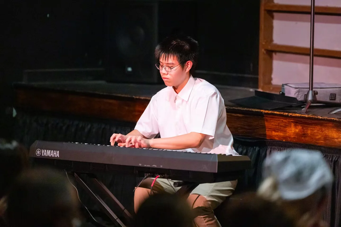 Lala playing a keyboard in a warm, dimly lit space